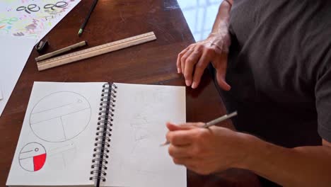 Hombre-Aficionado-Dibujando-Un-Boceto-En-Su-Cuaderno