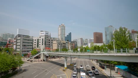 Travelers-ar-Seoullo-7017-skygarden-walkway-over-the-Seoul-and-cars-stoped-on-red-traffic-light,-South-Korea-city-skyline