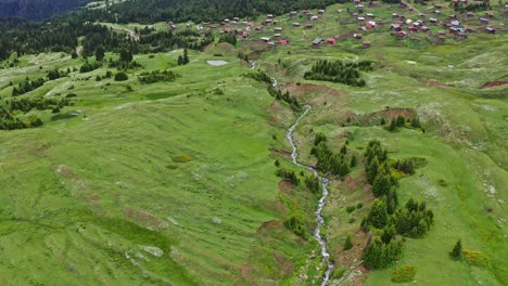 Flying-Over-Green-Hills,-River-And-Woodland-In-Highland-Countryside-Of-Georgia