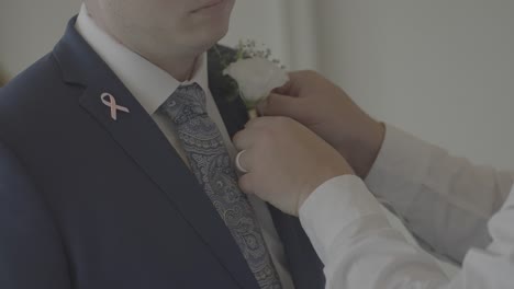 Best-man-fixing-boutonniere-on-grooms-lapel