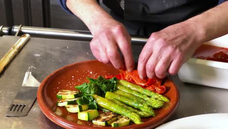 Der-Koch-Fügt-Geröstete-Paprika-Zu-Einem-Salat-Mit-Spargel,-Zucchini,-Spinat-Und-Pilzen-Hinzu