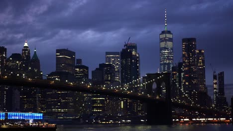 Timelapse-of-dark-clouds-moving-over-the-illuminated-Brooklyn-Bridge-and-the-Manhattan-skyline,-in-gloomy-USA