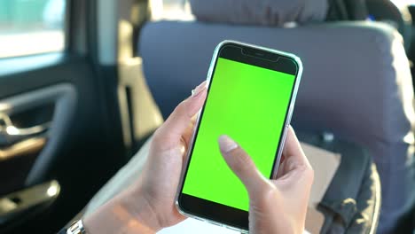 Woman-Holding-Phone-inside-a-Car-Taps-Green-Screen-Phone-Static