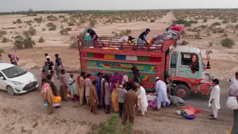 To-help-flood-victims-who-have-been-relocated-and-harmed-by-the-recent-flood-in-Pakistan,-individuals-are-giving-food-in-trucks