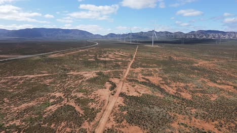Drone-aerial-over-renewable-energy-wind-power-warm-in-outback-desert-Australia-wind-power-farm-near-mountains