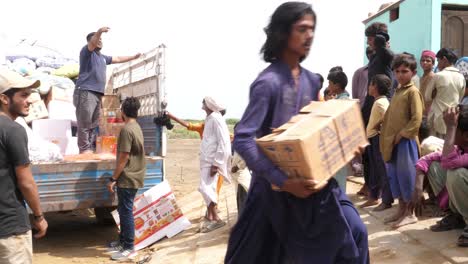 Obdachlose-Pakistaner-Sammeln-Nach-Der-Verheerenden-Überschwemmung-In-Pakistan-Im-Jahr-2022-Lebensmittel-Aus-Einem-Hilfslastwagen