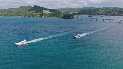 Boats-cruising-out-of-Samana-Bay-with-Puente-De-Cayo-Samana-in-background