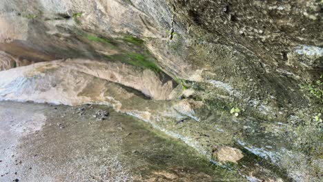 Wasser-Tropft-Von-Der-Felsformation,-Nahaufnahme-Von-Felsen-Mit-Moos-Und-Wasser