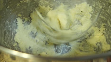Close-up-looking-down-at-butter-in-a-stand-mixer-being-mixed