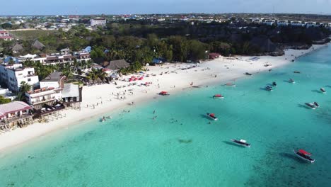A-stunning-aerial-view-of-Nungwi-beach-and-Nungwi-town-with-a-lot-of-water-and-beach-activities-on-the-ocean-including-many-boats