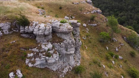 Aerial-view-across-rugged-stone-rock-formation-on-Peak-district-forested-hillside