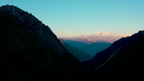 Drone-flight-over-a-Swiss-Alpine-valley-at-sunset