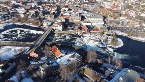 Static-aerial-looking-down-at-Kongsberg-city-bridge-crossing-Numedalslagen-river-during-sunny-winter-morning