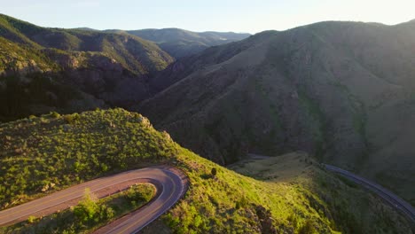 Aerial-Shot-Flying-Over-Winding-Mountain-Road-Revealing-Shadowy-Dark-Mountain-Valley-During-Sunset-Near-Denver-Colorado-USA
