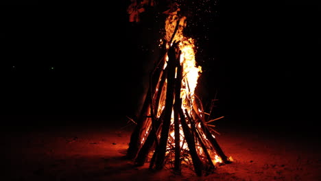 Burning-campfire-on-the-beach-Isolated-on-black-background