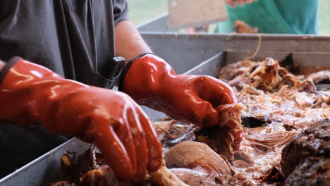 Man-pulling-pork-BBQ-off-a-cooked-hog