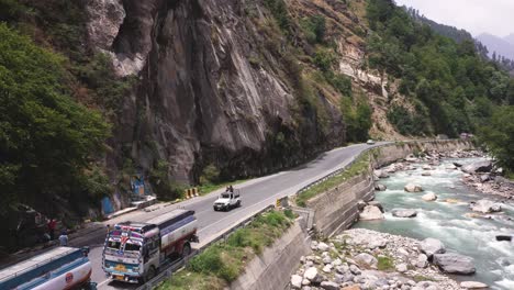 Aerial-drone-backward-moving-shot-over-road-leading-uptp-Manali,-Himachal-Pradesh-at-daytime