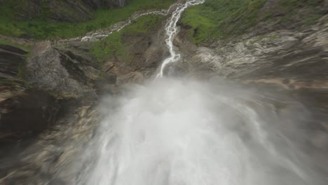 Dynamic-descending-flight-over-splashing-waterfall-in-Norway-named-Skytjefossen-in-Norway