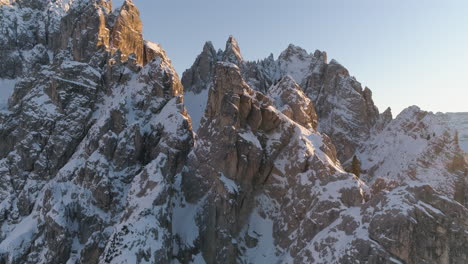 Felsige,-Schneebedeckte,-Sonnendurchflutete-Berggipfel-Der-Drei-Zinnen,-Luftaufnahme-Vom-Gipfel-Weg