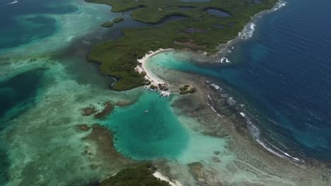 Aerial-shot-of-Boca-Seca-Key,-located-in-Morrocoy-National-Park-in-Venezuela,-surrounded-by-crystal-clear-waters-and-coral-reefs