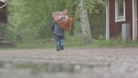 EXTREME-WEATHER---A-child-with-an-umbrella-runs-through-the-heavy-rain