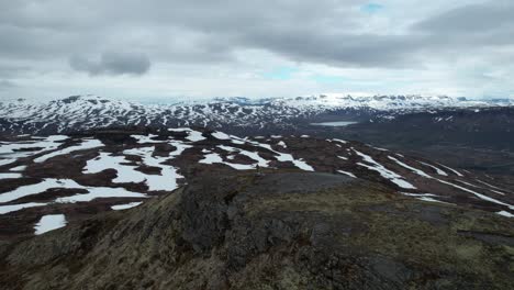 Aerial-View-Of-Person-Standing-On-Hilltop-In-Hardangervidda-National-Park-Over-Snow-Covered-Landscapes