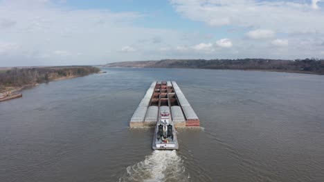 Aerial-close-up-panning-shot-of-a-river-barge-transporting-goods-on-the-Mississippi-River