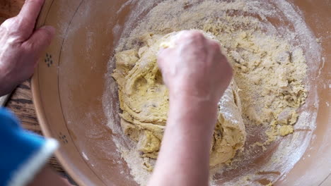 Elderly-Woman-baking-and-kneading-biscuit-dough-in-kitchen-,-top-view
