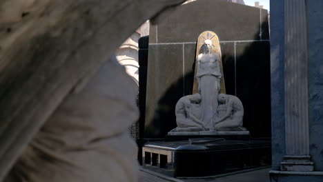 Dos-Hombres-Orando-A-La-Estatua-De-Jesus-En-El-Estante-De-Enfoque-Del-Cementerio-De-La-Recoleta