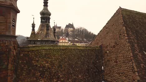 A-drone-shot,-with-leftward-trucking-motion,-capturing-a-glimpse-of-the-vintage-architechture-in-the-city-of-Sighisoara-on-an-afternoon