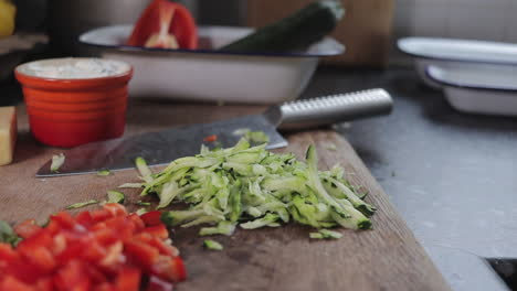 Diced-zucchini--courgette-being-dropped-onto-wooden-chopping-board