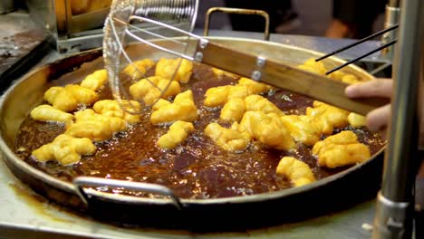 Frying-deep-fried-dough-stick-in-the-pan-at-Yaowarat-Road-Chinatown,-a-popular-travel-destination-in-Bangkok,-Thailand