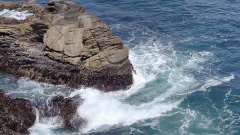 Ultra-slow-motion-shot-of-waves-crashing-rocks-in-the-ocean,-California,-USA
