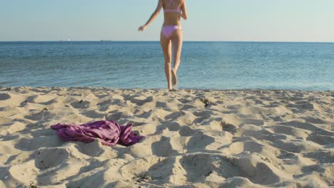 Woman-on-vacation-excitedly-runs-into-the-water