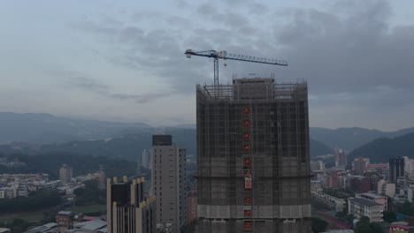 Una-Toma-De-Drone-De-Un-Edificio-En-Construcción-En-Taipei-Al-Atardecer-Donde-Se-Puede-Ver-Un-Ascensor-Subiendo