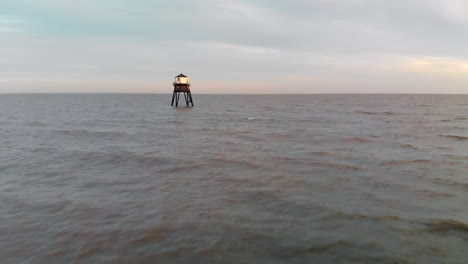 Aerial-footage-moving-out-to-sea-over-a-lighthouse