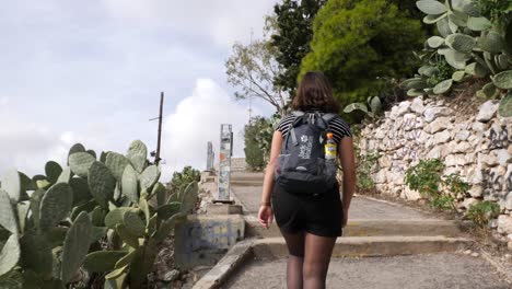 A-young-asian-woman-hikes-up-a-path-to-a-mountain-in-Athen