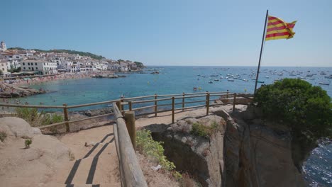 Playa-Con-Gente,-Calella-De-Palafrugell,-Mediterraneo-Mar,-Flag-Cataluña
