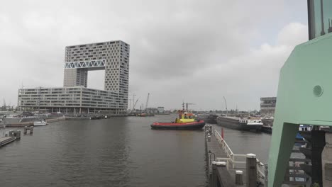 A-shot-of-the-Houthavens-in-Amsterdam,-showing-the-Pontsteiger-building-and-a-red-boat-in-the-harbour-of-this-Dutch-city