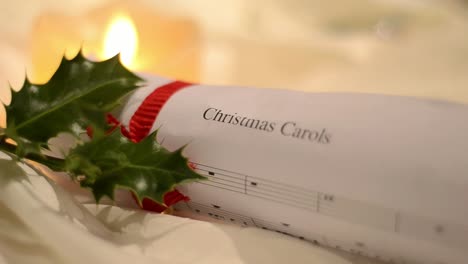 Christmas-Carol-Music-Sheet-with-Holly-and-Candlelight