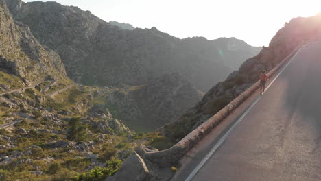 Aerial-view,-guy-running-on-the-road-of-Tramuntana-mountains,-Sa-Calobra,-Mallorca