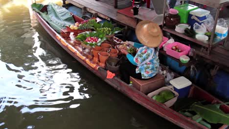 Frau-Serviert-Essen-Aus-Ihrem-Boot-Auf-Dem-Thailändischen-Schwimmenden-Markt