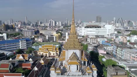 Slow-crane-shot-of-Wat-Traimit-and-the-skyline-of-Bangkok,-Thailand