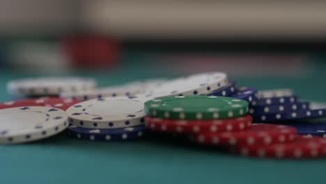 Close-up-of-a-pile-of-poker-chips-on-a-table-as-more-are-added-to-the-pile-as-betting-takes-place