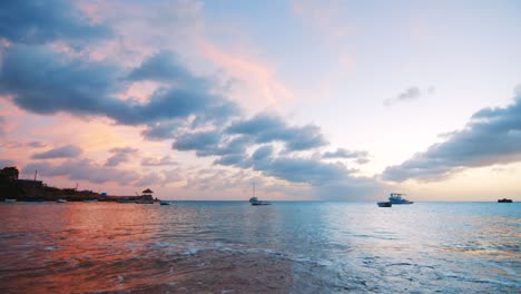 Landschaft-Vom-Strand-Aus-Mit-Mehreren-Fischerbooten,-Die-Während-Des-Sonnenuntergangs-In-Boka-Sami,-Curacao,-Im-Hafen-Liegen