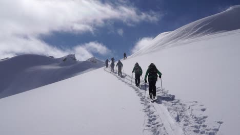 Gruppe-Von-Backcountry-Skifahrern,-Die-Den-Skintrack-Hinaufsteigen-Und-Sich-Dem-Gipfel-Nähern