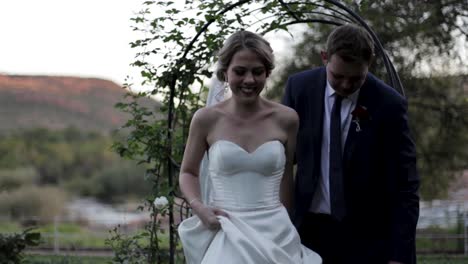 Newlywed-couple-walks-past-the-camera-smiling-showing-their-joy-and-happiness-after-getting-married