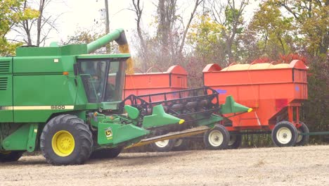 Wide-shot-of-John-Deere-9600-Combines-unloading-soybeans-into-a-trailer-after-harvesting