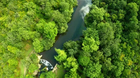 Aerial-view-of-the-trees,-forests-and-river-in-the-Derbyshire-Peak-District-National-Park-near-Bakewell,-commonly-used-by-cyclists,-hikers,-popular-with-tourists-and-holiday-makers