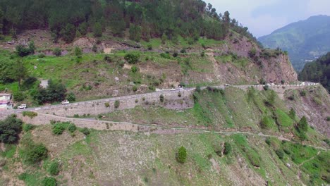 Highway-at-the-top-of-the-mountain-and-a-river,-Nepal,-Traffic-on-the-road,-Hill-with-trees-and-forest,-camera-pan-shot